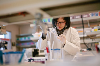 Scientist pipetting into a tube